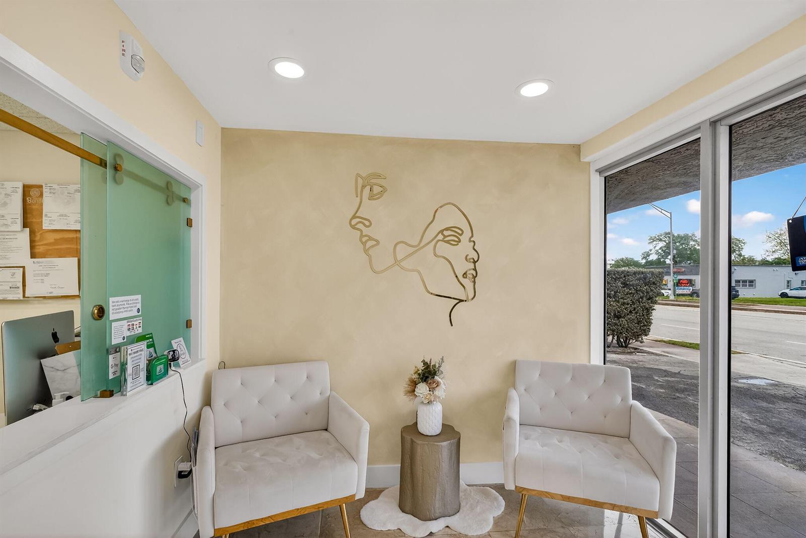 A waiting area features two white tufted chairs, a gold line-art wall decal, and floor-to-ceiling windows — Null Null Avenue, Miami FL 33145, MIAMI, FL