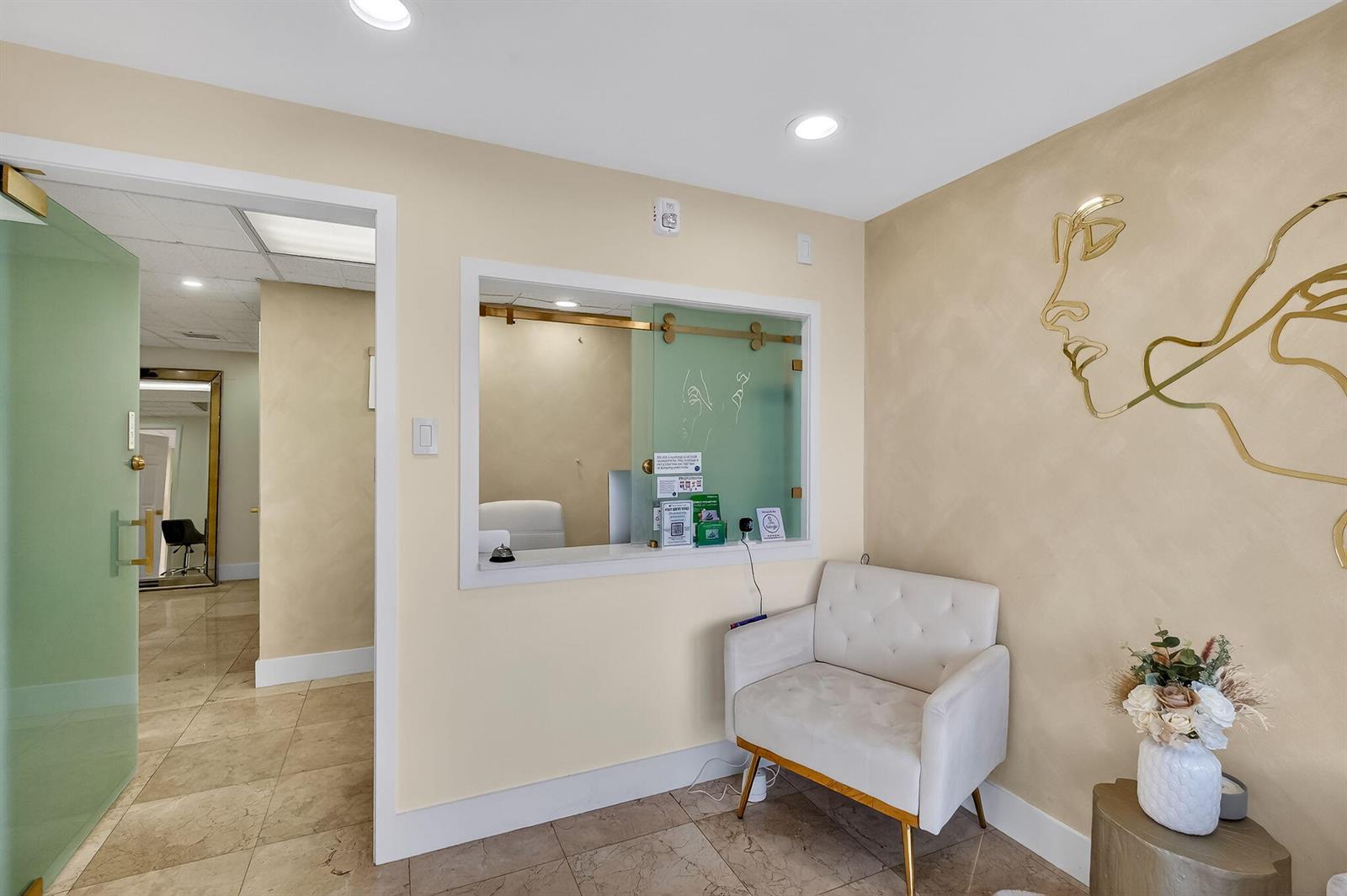 A waiting area features a reception window, a white tufted chair, and gold wall art — Null Null Avenue, Miami FL 33145, MIAMI, FL