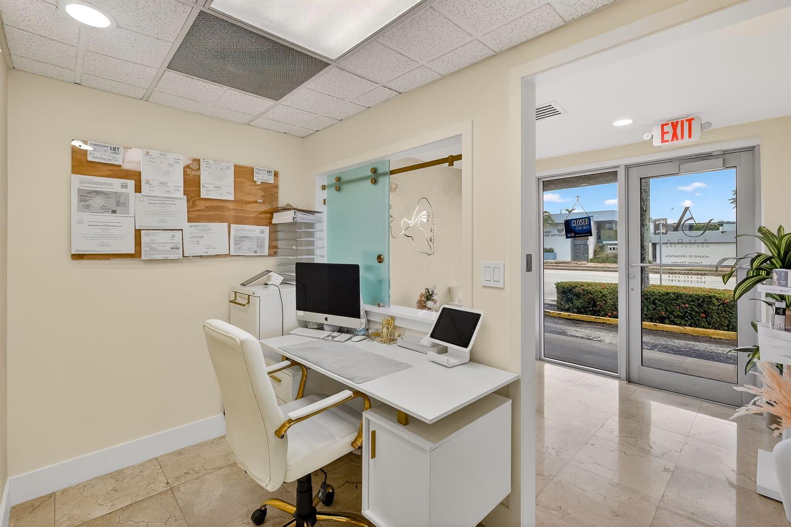 A reception office features a white desk, computer, swivel chair, and a glass door entrance — Null Null Avenue, Miami FL 33145, MIAMI, FL