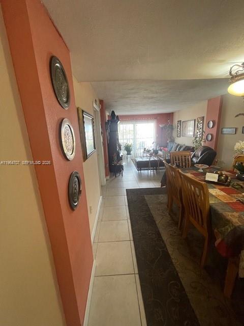 A dining area with a tiled floor leads into a living room with sliding glass doors — 14250 SW 62nd St # 320, Miami FL 33183, MIAMI, FL