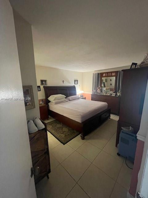 A bedroom features a dark wood bed frame, tile flooring, and a wooden dresser — 14250 SW 62nd St # 320, Miami FL 33183, MIAMI, FL