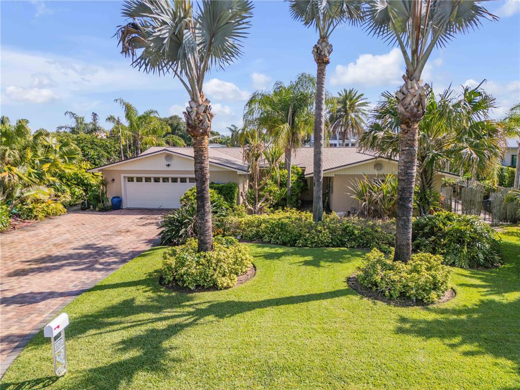 A single-story house with a paved driveway, palm trees, and a green lawn — 109 VIA BENEVENTO, NEW SMYRNA BEACH, FL
