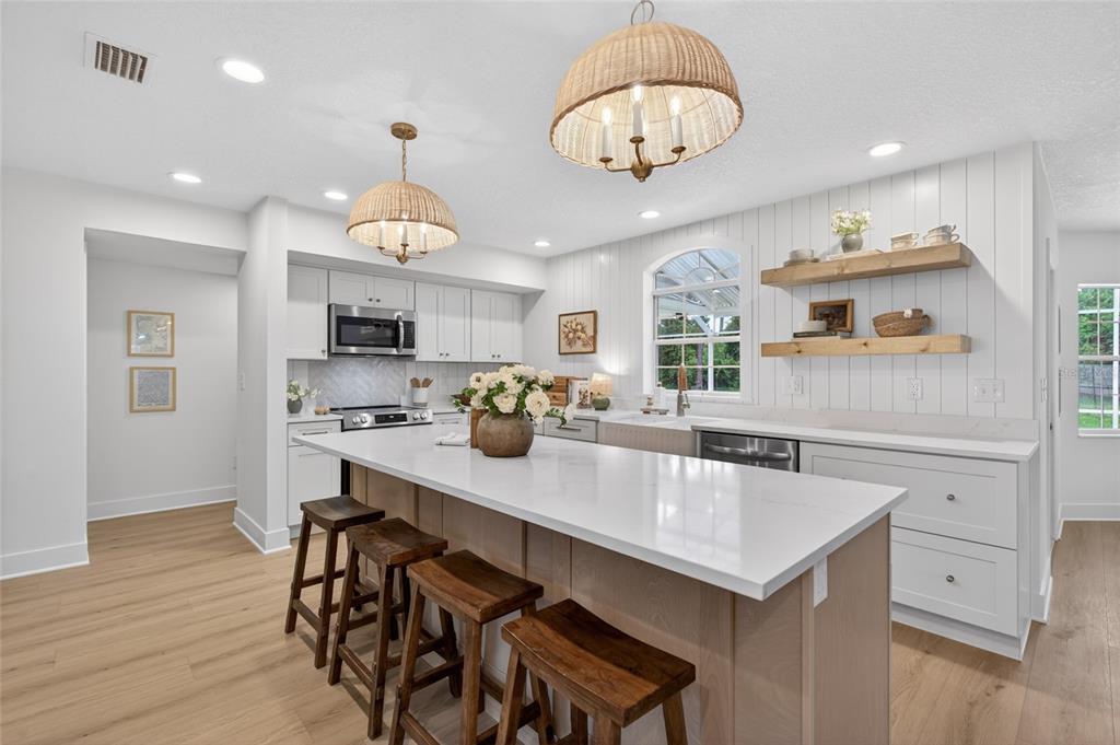 A dining room features a wooden table, white spindle chairs, and board-and-batten wall paneling — 13 ELLSWORTH DRIVE, PALM COAST, FL