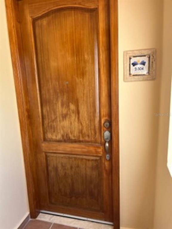 A wooden door with a decorative room number plaque on the adjacent beige wall — Palms Inn Drive PALMANOVA VILLAGE UNIT 2-304, HUMACAO, PR