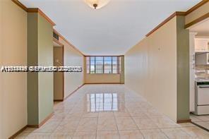 A view of a tiled living area with light-colored walls and a large window — 2025 NE 164th St # 904, North Miami Beach FL 33162, NORTH MIAMI BEACH, FL