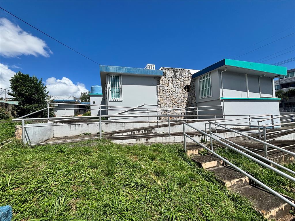 A gray building with a stone facade features a wheelchair ramp and concrete stairs — 47 AVE JOSE DE DIEGO UNIT 32, SAN JUAN, PR