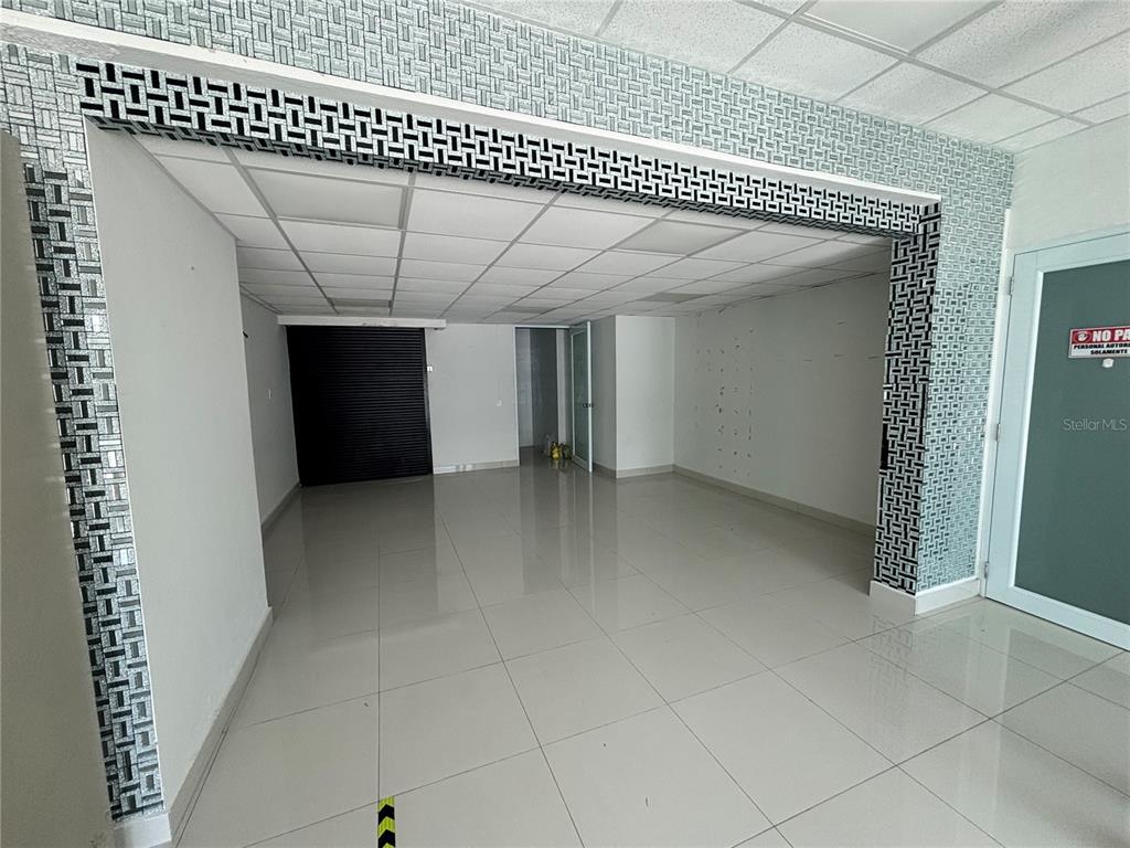 An empty commercial space features white tile flooring, a drop ceiling, and decorative tiled columns — 47 AVE JOSE DE DIEGO UNIT 32, SAN JUAN, PR
