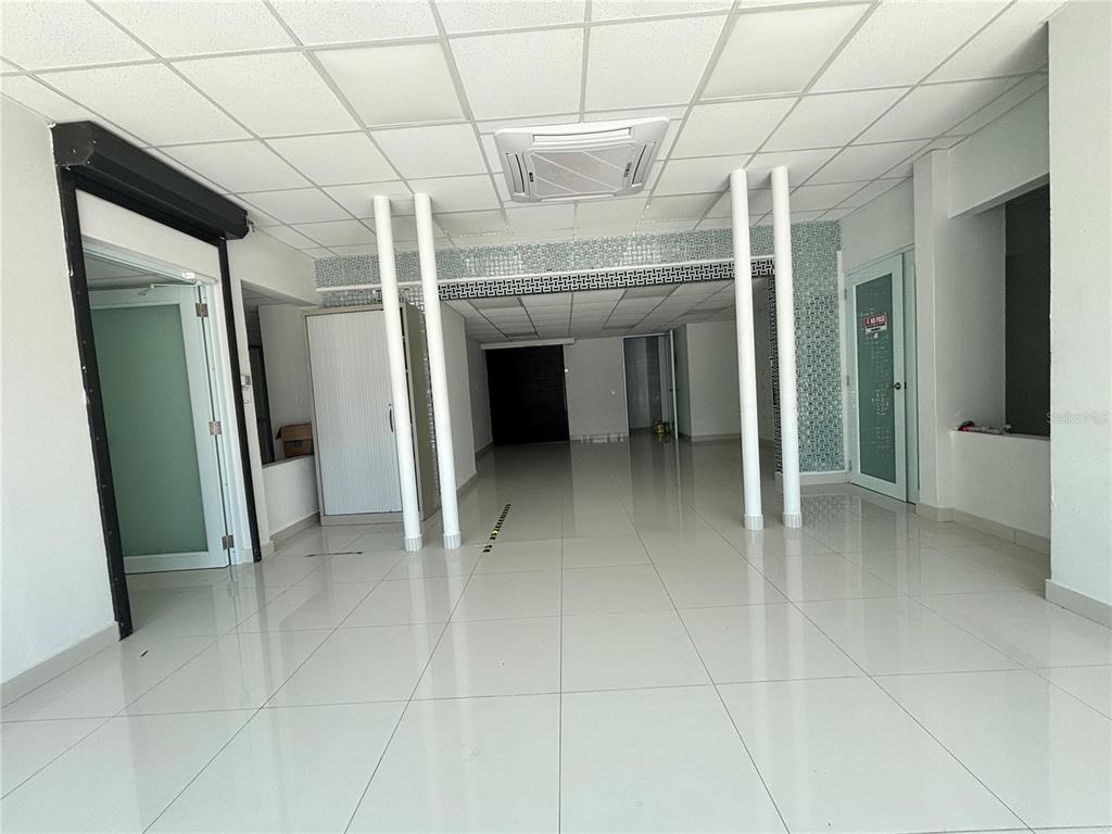 An empty commercial space features white tiled floors, a drop ceiling, and two support columns — 47 AVE JOSE DE DIEGO UNIT 32, SAN JUAN, PR