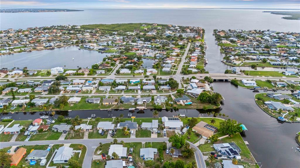 An aerial view of a coastal residential neighborhood with houses situated along canals and waterways — 180 PALMETTO CIRCLE NE, PORT CHARLOTTE, FL