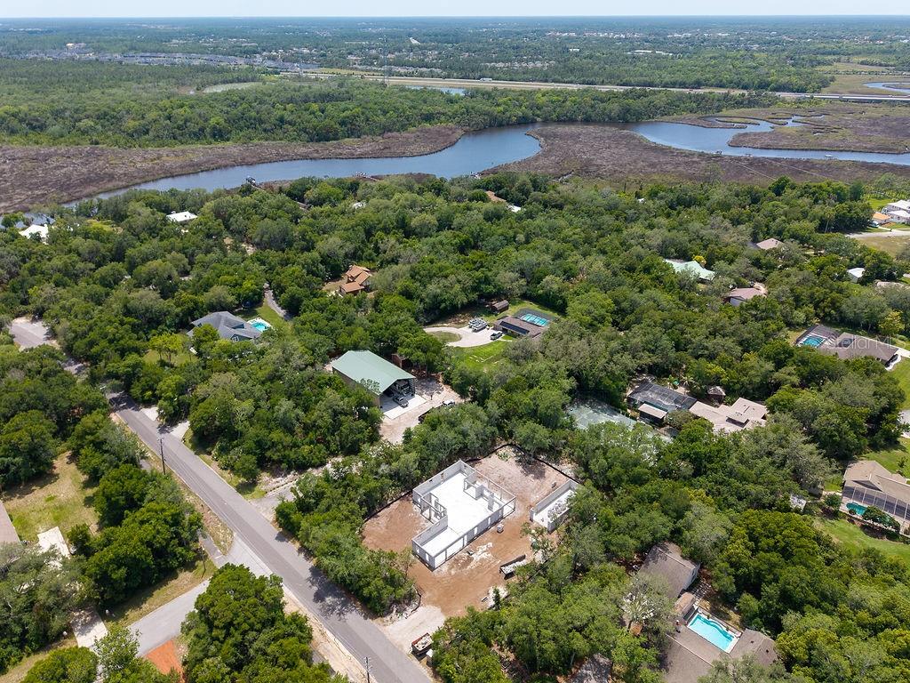 An aerial view shows a residential neighborhood with a house under construction and nearby water — 6030 HENSEL ROAD, PORT ORANGE, FL