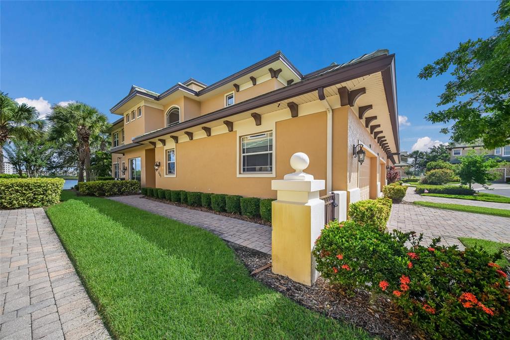 A two-story tan stucco house with a tiled roof and a paved walkway — 6435 MOORINGS POINT CIRCLE UNIT 201, LAKEWOOD RANCH, FL
