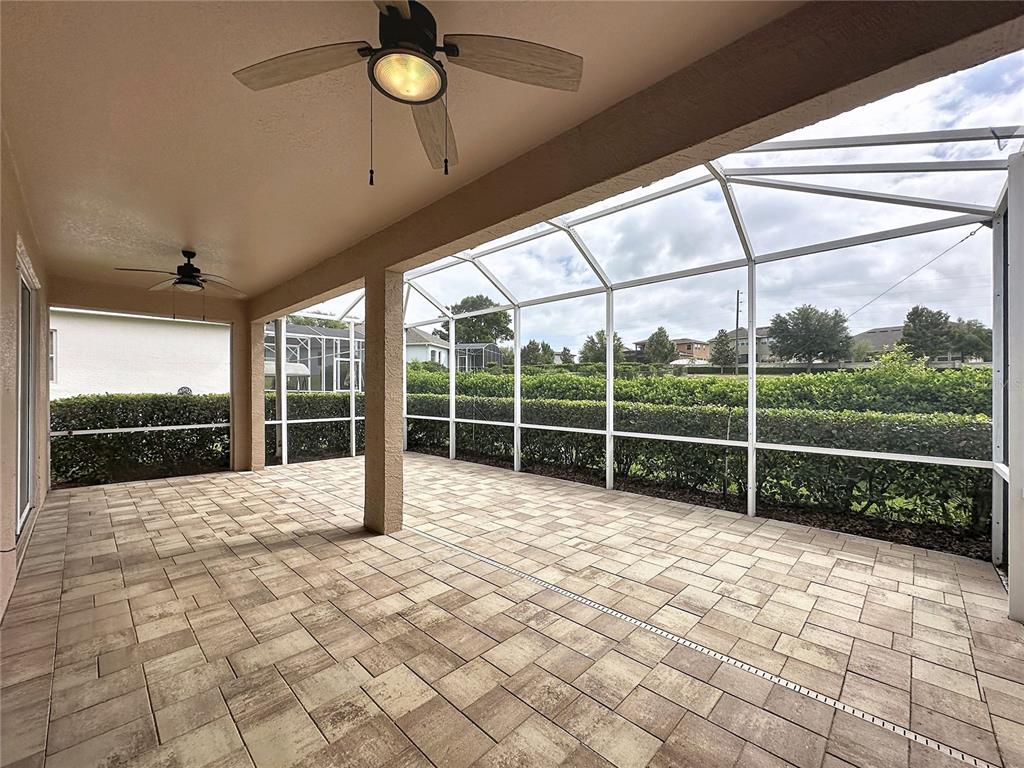 A covered patio features paver flooring, two ceiling fans, and a screened-in enclosure — 4127 KINGSLEY STREET, CLERMONT, FL