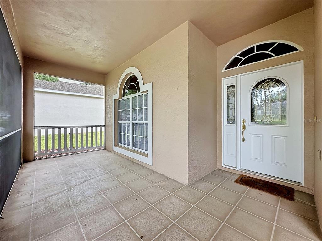 A covered porch features tiled flooring, a white front door with glass, and a large window — 4127 KINGSLEY STREET, CLERMONT, FL