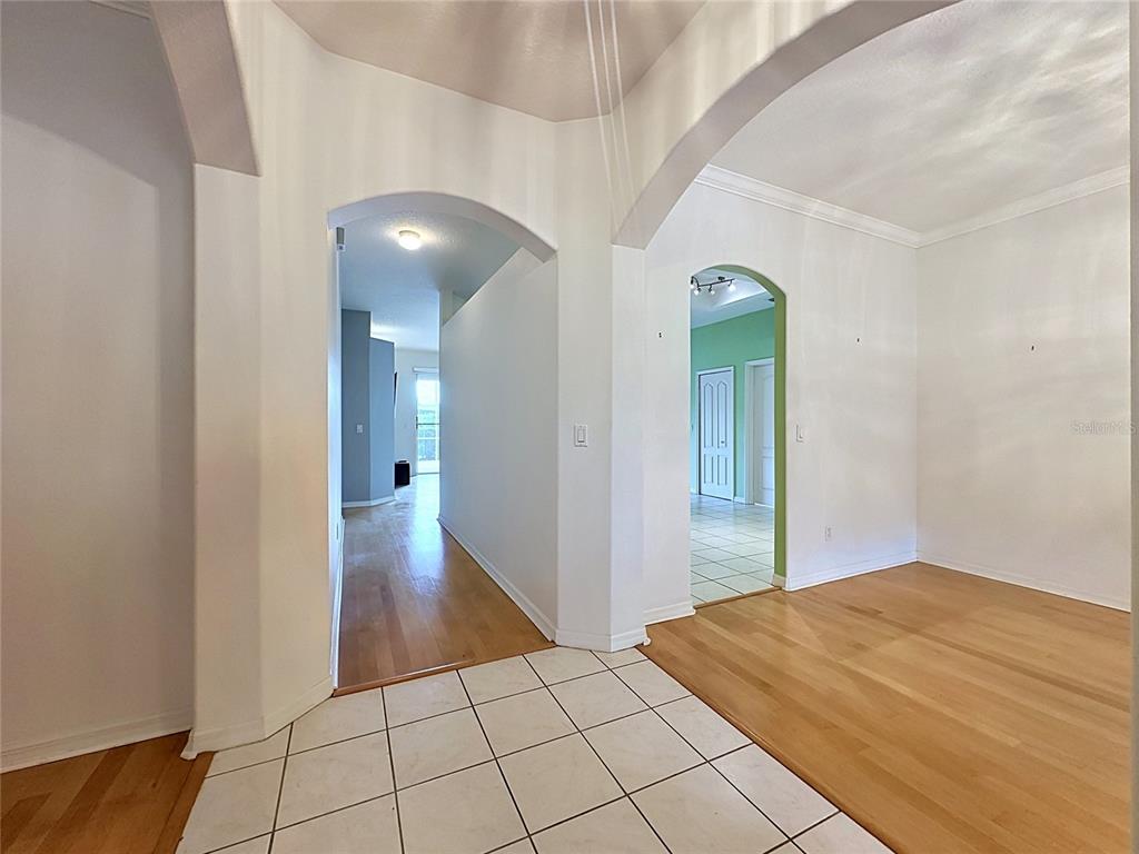 A tiled entryway leads to a hallway with hardwood floors and an arched doorway — 4127 KINGSLEY STREET, CLERMONT, FL