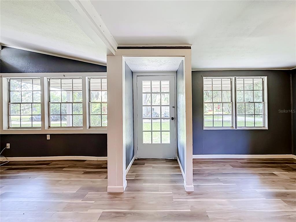 An interior room features dark gray walls, wood-look flooring, and a central glass-paned door — 1880 CR 422, LAKE PANASOFFKEE, FL
