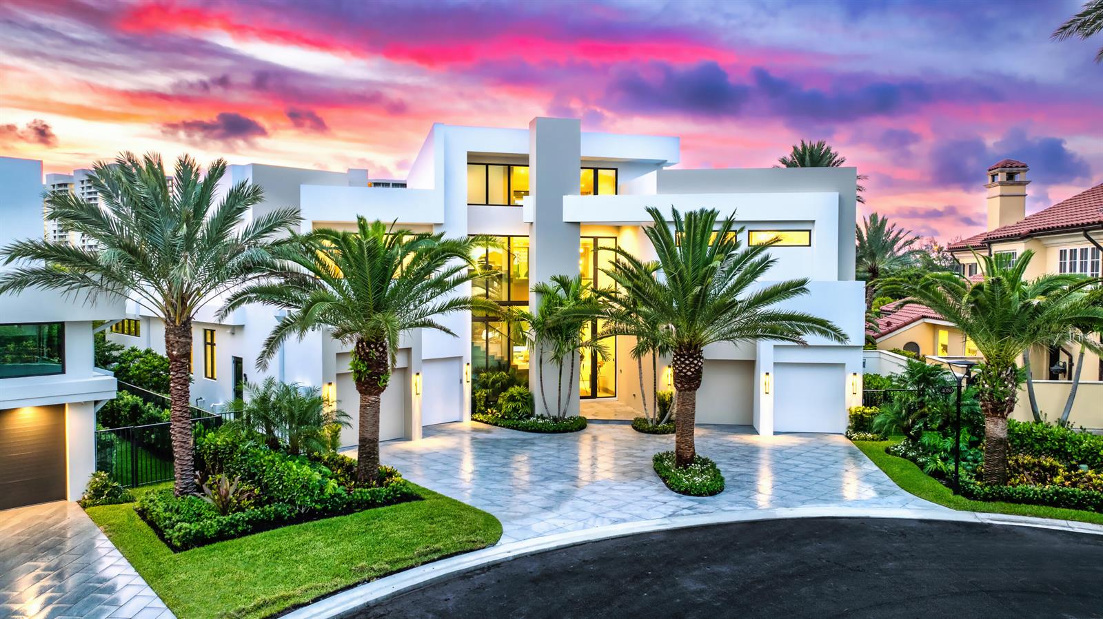A modern white multi-story house with a paved driveway and palm trees at sunset — 4080 Ibis Point Circle, Boca Raton FL 33431, BOCA RATON, FL