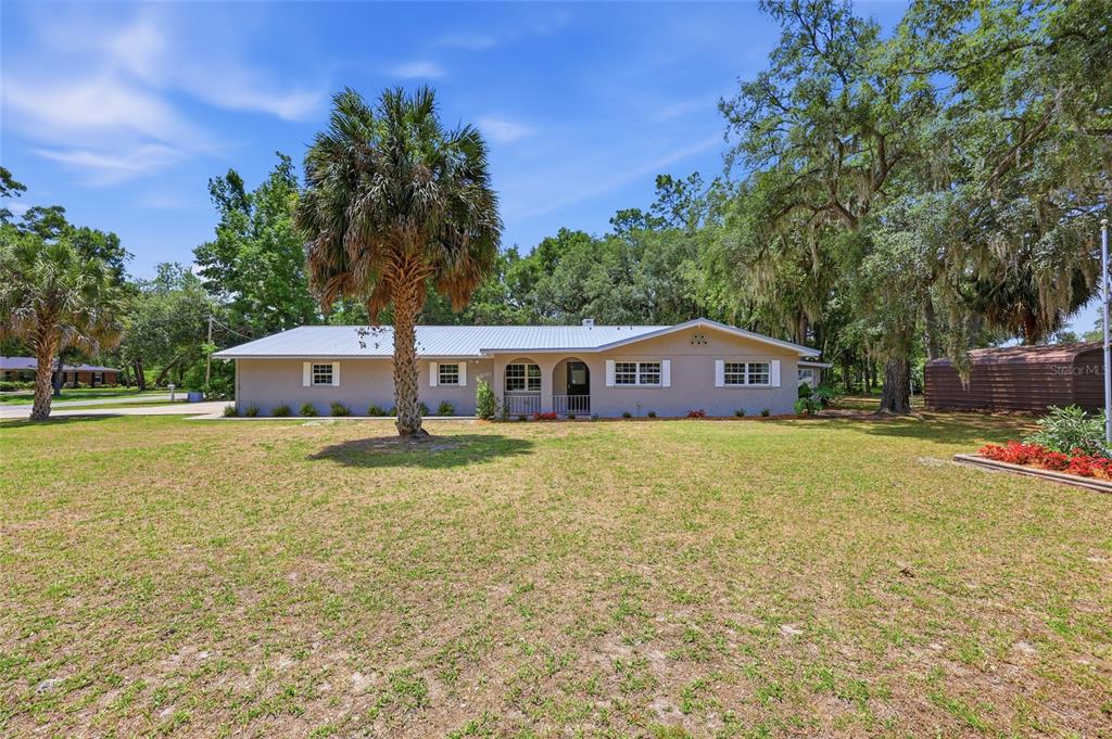 A single-story house with a metal roof and a palm tree in the front yard — 9350 NW 114TH STREET, CHIEFLAND, FL