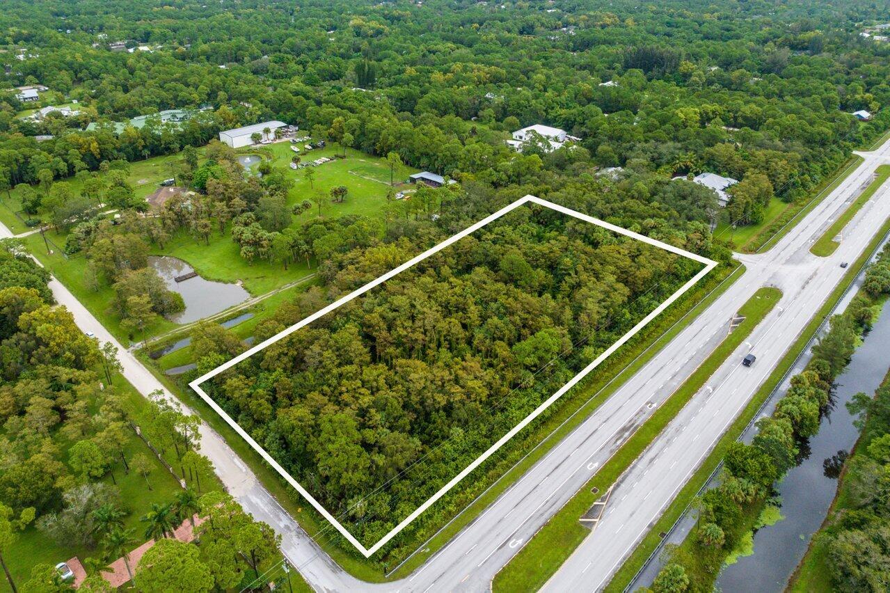 An aerial view shows a rectangular, tree-covered vacant lot bordered by a road and canal — Xxxxx Indiantown Road, Jupiter FL 33478, JUPITER, FL