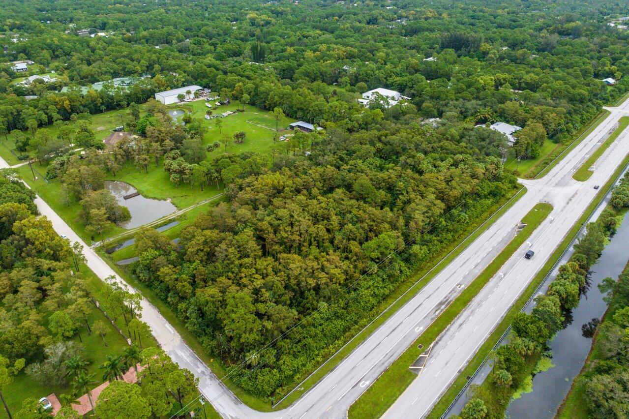 An aerial view shows a wooded lot adjacent to a multi-lane highway and a pond — Xxxxx Indiantown Road, Jupiter FL 33478, JUPITER, FL