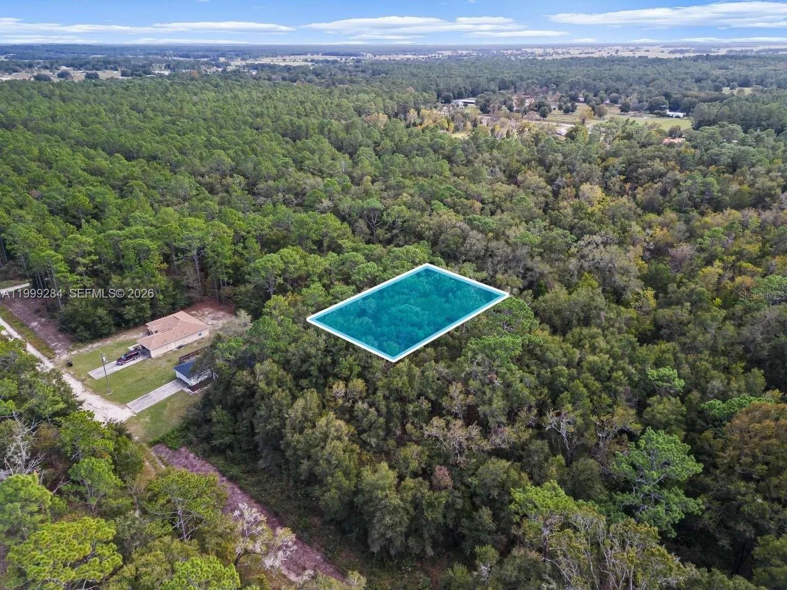 An aerial view shows a rectangular plot of land highlighted in blue amidst dense forest — 0 SW 30th ST, Ocala FL 34481, OCALA, FL