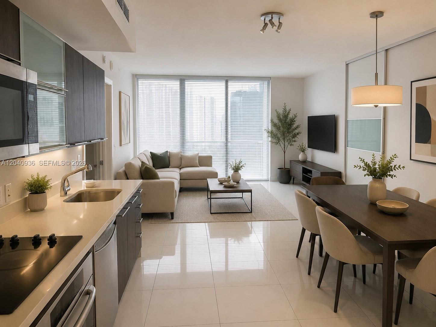 A modern open-concept living and dining area features a kitchen with dark cabinetry and tile floors — 90 SW 3rd St # 3610, Miami FL 33130, MIAMI, FL