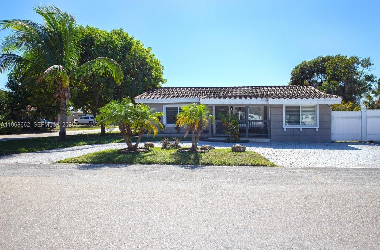 A single-story house with a tiled roof, gray exterior, and a paved driveway — 2450 NE 18th St, Pompano Beach FL 33062, POMPANO BEACH, FL
