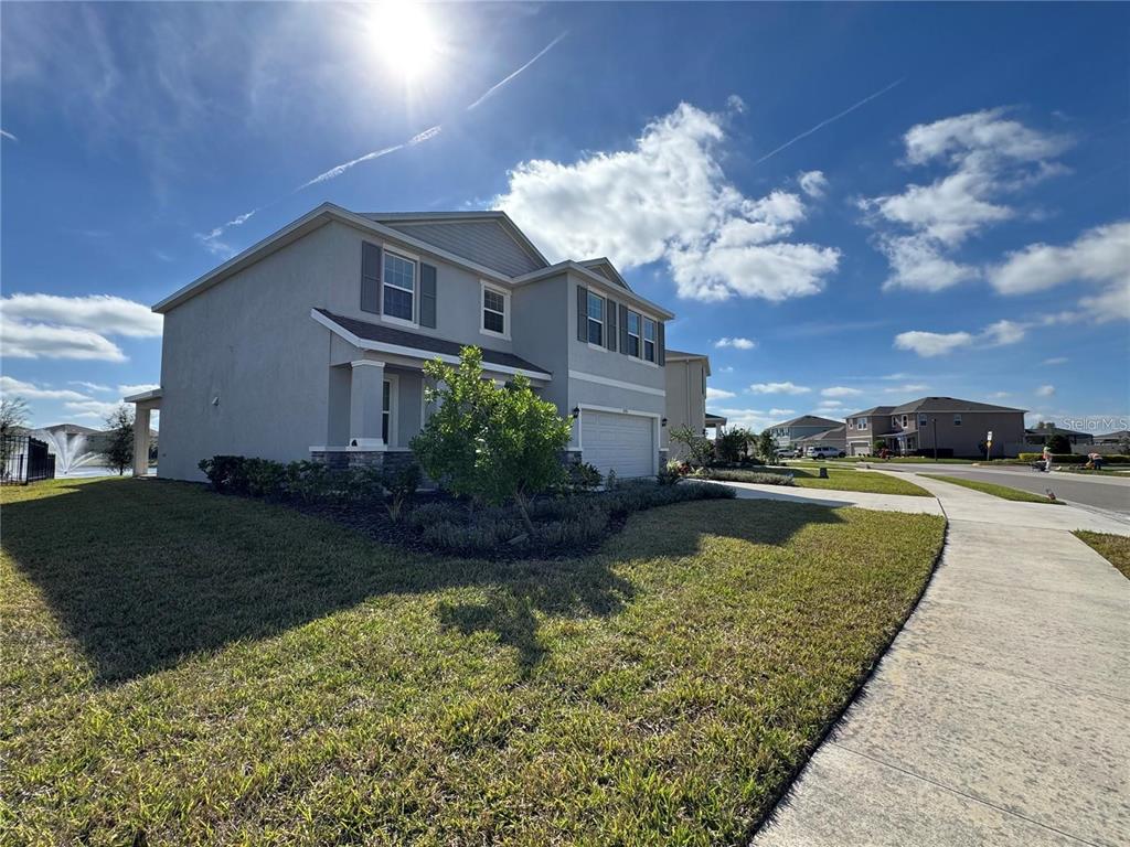 A two-story suburban house with a gray exterior, a garage, and a landscaped front yard — 17710 CANTARINA COVE, BRADENTON, FL