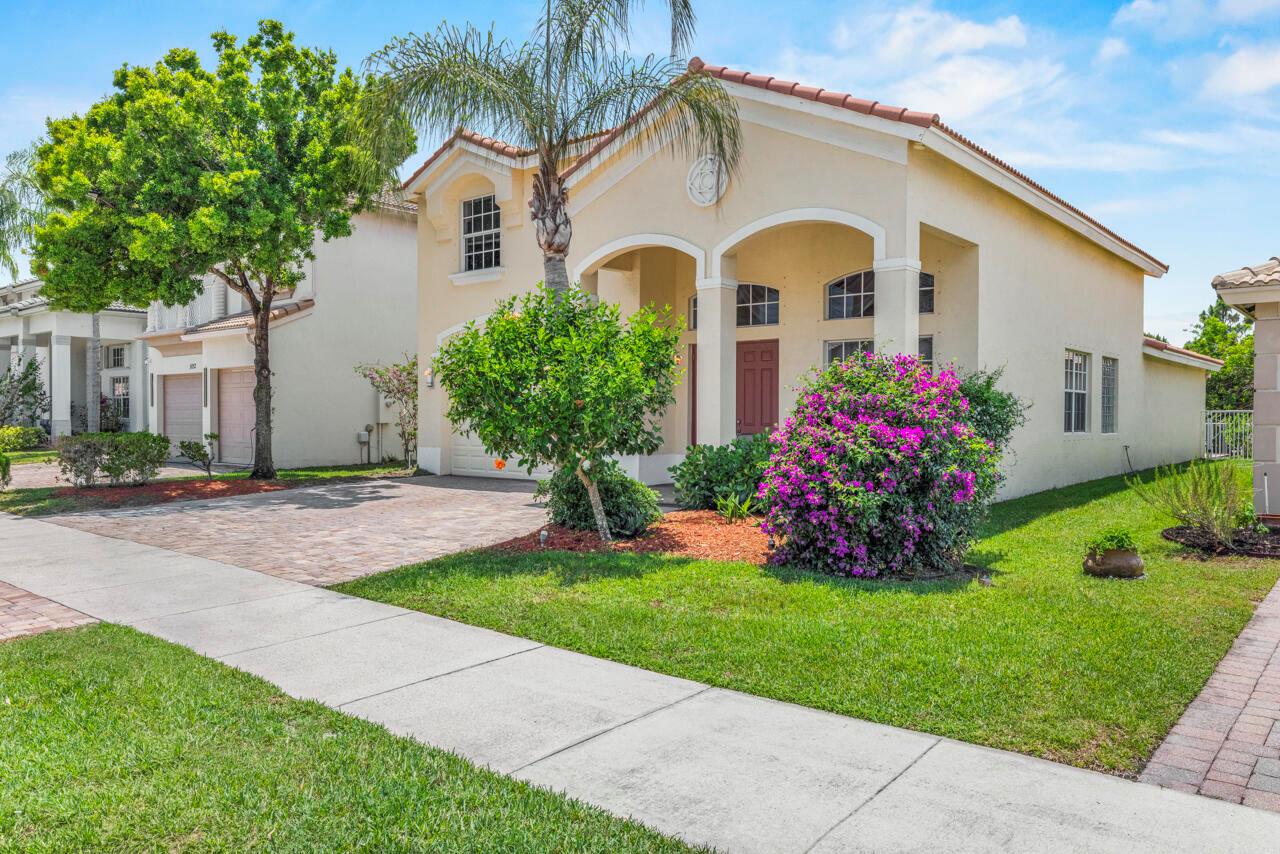A beige single-story house with a tile roof, palm tree, and flowering bush in front — 5040 SE Graham Drive, Stuart FL 34997, STUART, FL