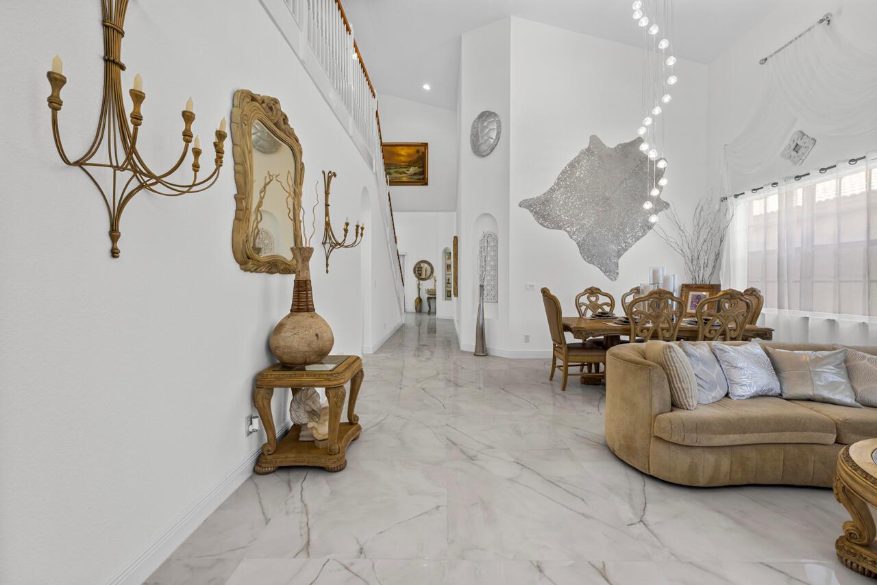 A bright, open-concept living and dining area features marble floors, high ceilings, and ornate decor — 5040 SE Graham Drive, Stuart FL 34997, STUART, FL
