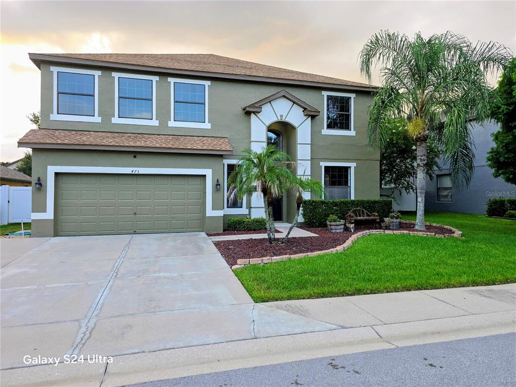A two-story house with olive green stucco, a two-car garage, and a palm tree — 473 OAK LANDING BOULEVARD, MULBERRY, FL