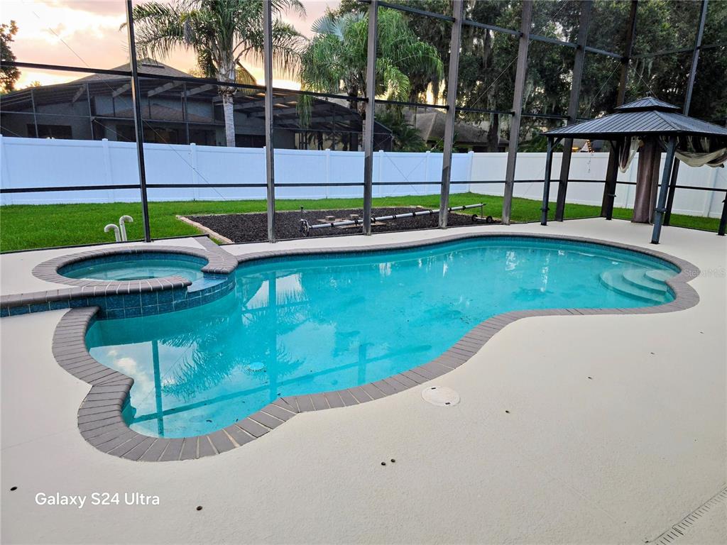 A backyard swimming pool with an attached spa and a gazebo inside a screened enclosure — 473 OAK LANDING BOULEVARD, MULBERRY, FL