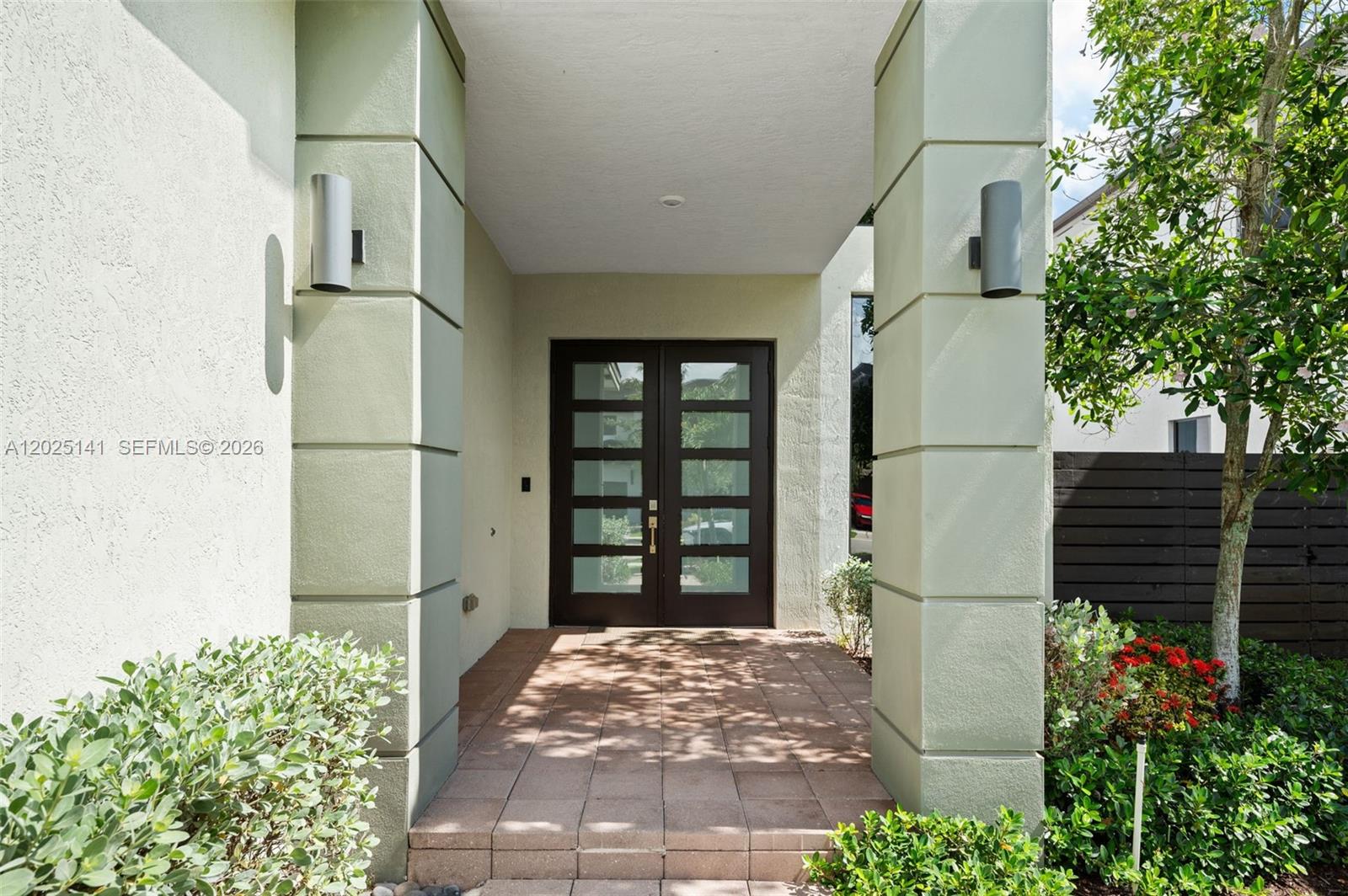 A covered entryway features a double door with glass panels between two large pillars — 8763 NW 157th Ter, Miami Lakes FL 33018, MIAMI LAKES, FL