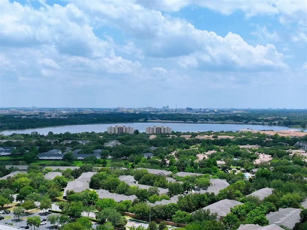 An elevated view shows a lake surrounded by residential buildings and dense green trees — 6451 OLD PARK LANE UNIT 204, ORLANDO, FL