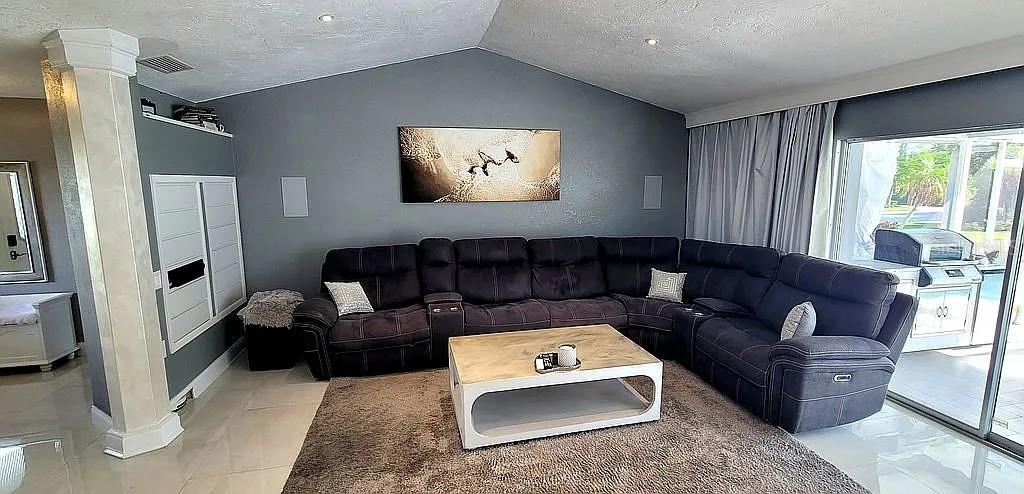 A living room features a large gray sectional sofa, a coffee table, and a wall painting — 1840 FLAMETREE LANE, VENICE, FL
