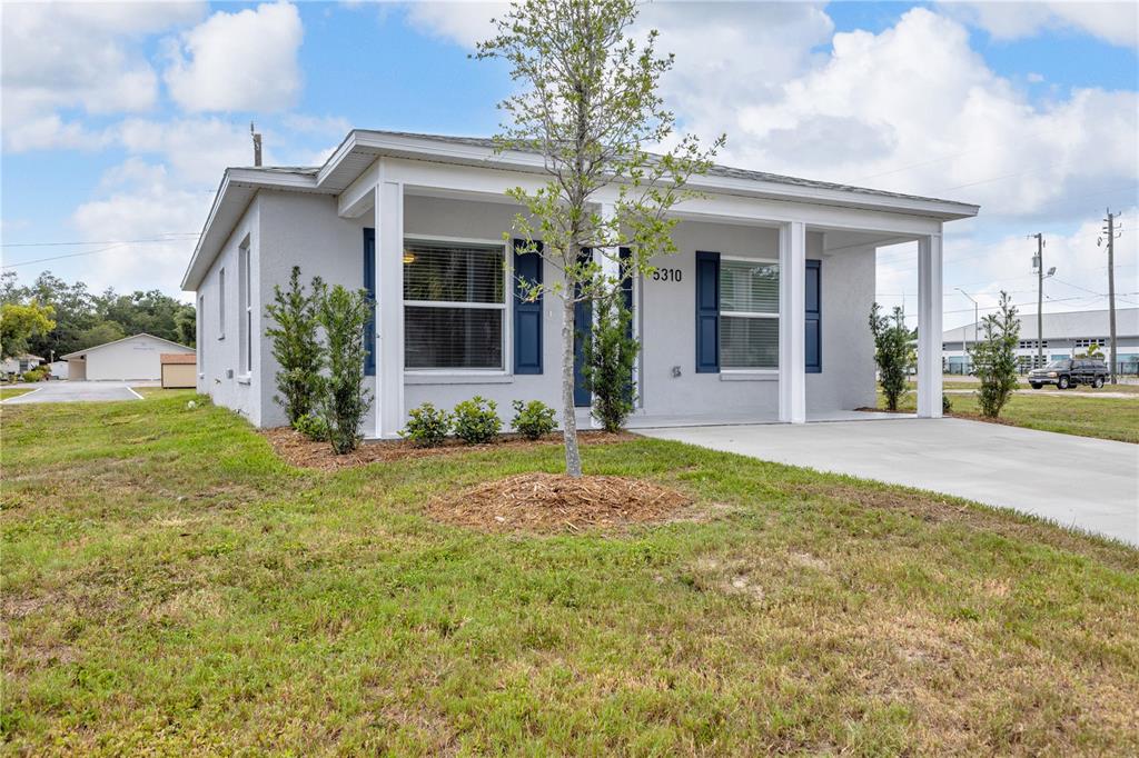 A single-story gray house with a covered front porch and blue shutters — 5310 22ND STREET COURT E, BRADENTON, FL