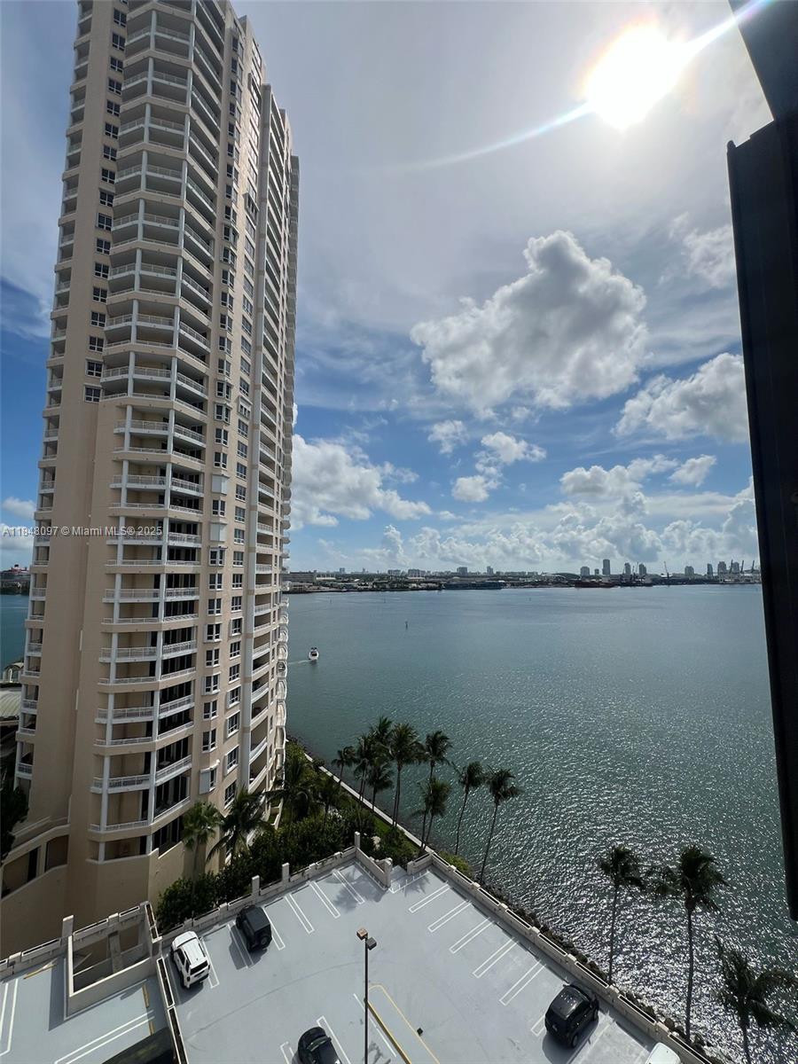 An elevated view shows a tall residential building overlooking a bay with a parking lot — 540 Brickell Key Dr # 1524, Miami FL 33131, MIAMI, FL