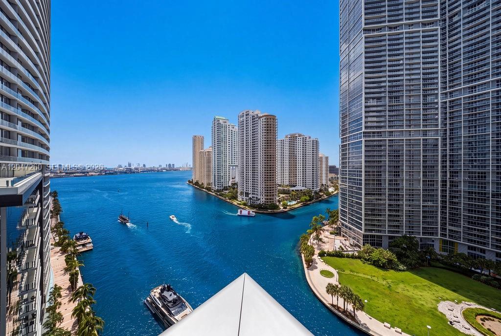 A high-angle view shows a waterway between tall residential towers with boats and green landscaping — 200 Biscayne Boulevard Way # 5110, Miami FL 33131, MIAMI, FL