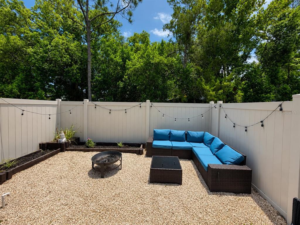 A backyard patio features a gravel ground, a fire pit, and a sectional outdoor sofa — 2029 SHULLER WAY, CASSELBERRY, FL