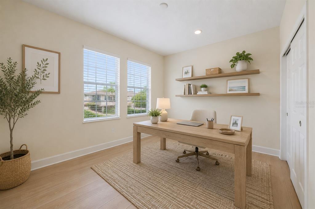 A home office features light wood flooring, a desk, floating shelves, and two windows — 8418 NANDINA DRIVE, SARASOTA, FL