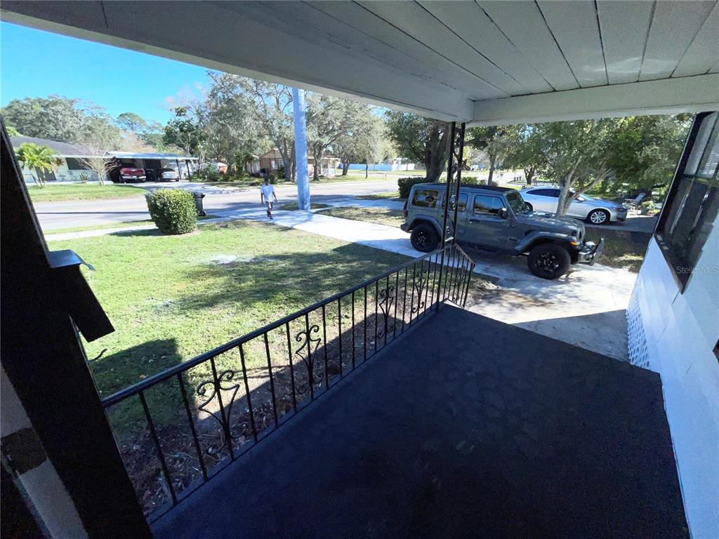 A view from a covered front porch looking out toward a yard, driveway, and street — 2525 37TH STREET S, ST PETERSBURG, FL