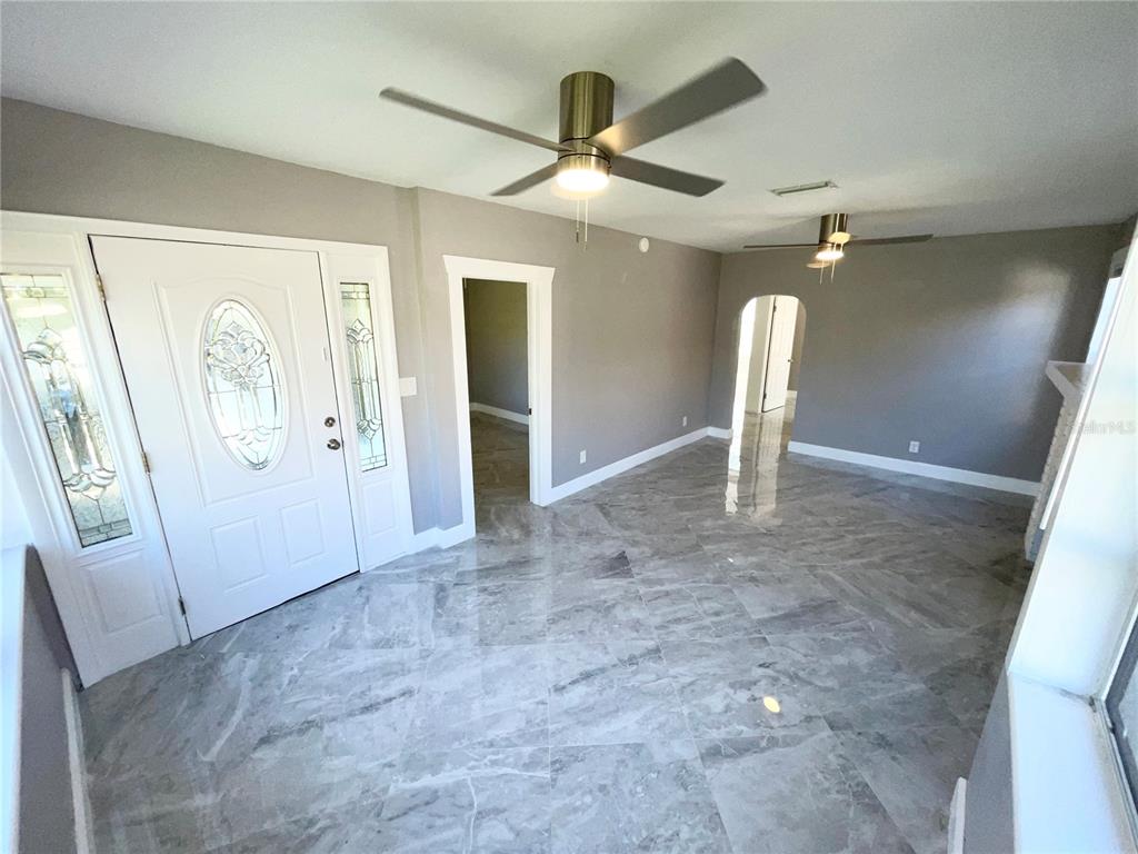 An entryway with gray marble-look tile flooring, a white front door, and two ceiling fans — 2525 37TH STREET S, ST PETERSBURG, FL