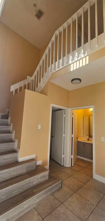 A kitchen features gray cabinets, stainless steel appliances, and a sink beneath a pass-through window — 14560 LAGUNA BEACH CIRCLE, ORLANDO, FL