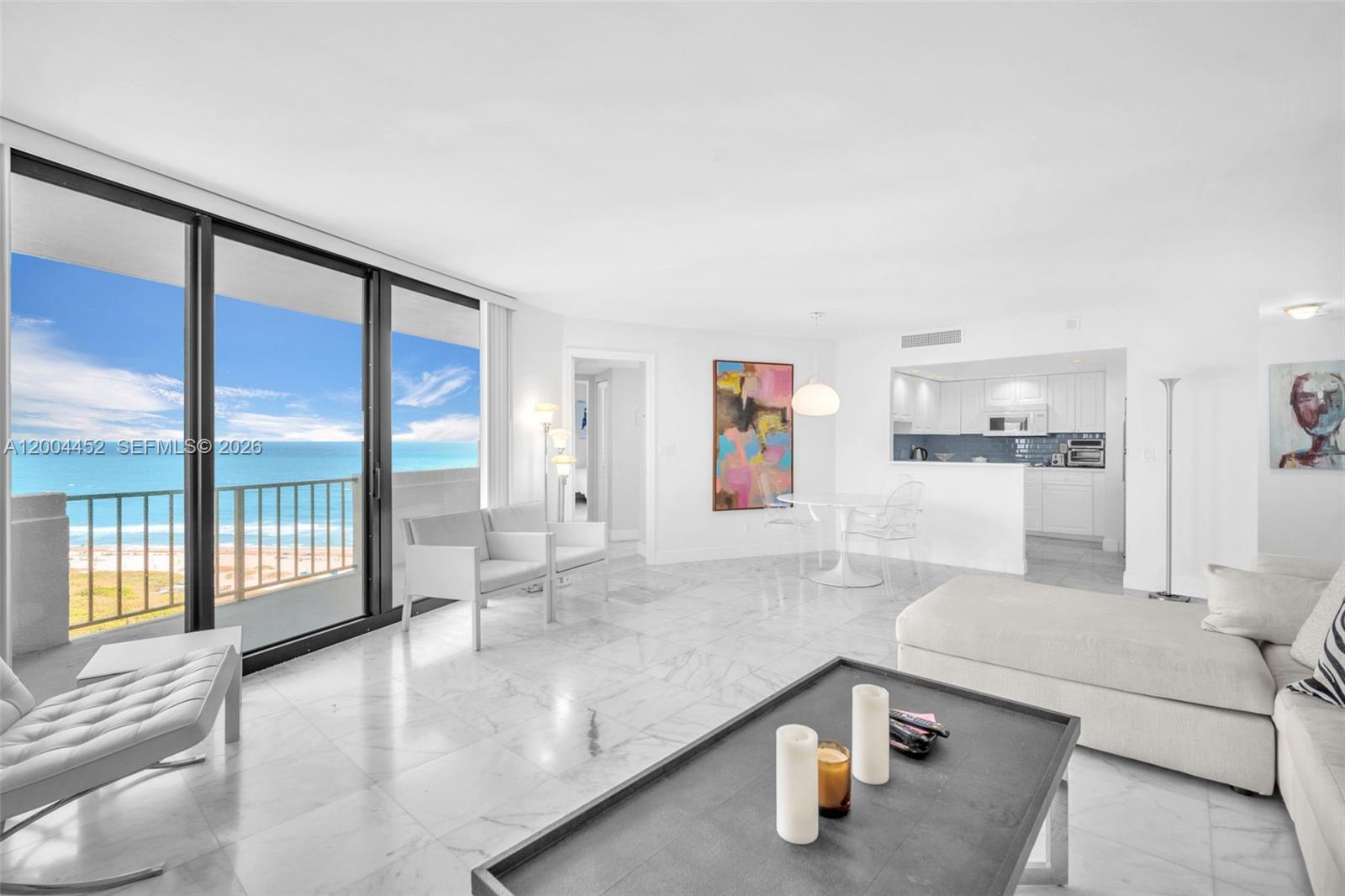 A bright living room with white marble floors, a modern kitchen, and a balcony overlooking the ocean — 2800 N Ocean Dr # 15C, Singer Island FL 33404, SINGER ISLAND, FL
