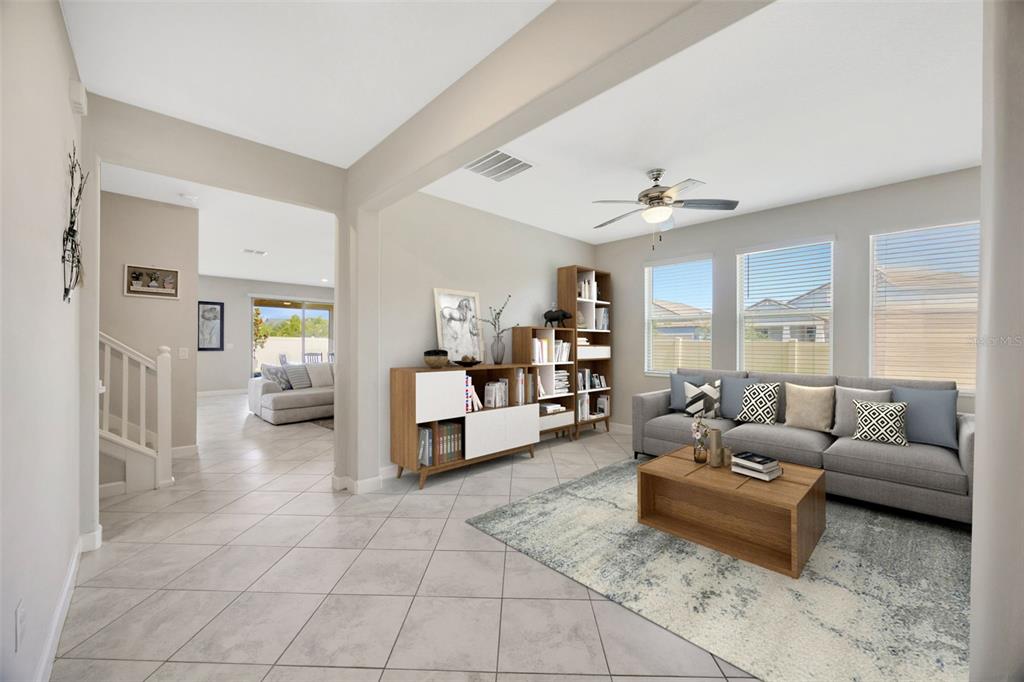 A living room with tile flooring, a gray sofa, and a wooden shelving unit — 11464 CHILLY WATER COURT, RIVERVIEW, FL