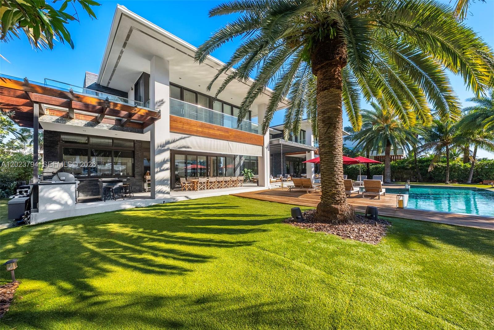 A modern two-story house features a backyard with a swimming pool and palm trees — 385 Centre Is, Golden Beach FL 33160, GOLDEN BEACH, FL
