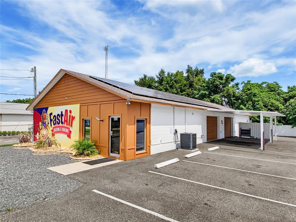 A commercial building with a brown facade, solar panels, and a parking lot — 3347 SW 7TH STREET, OCALA, FL