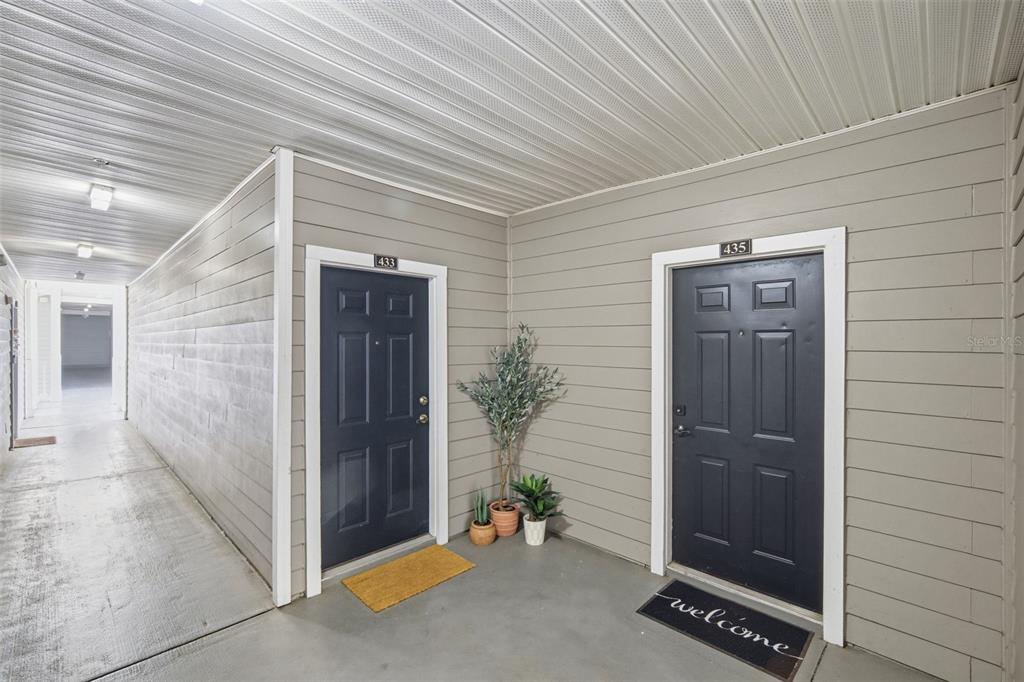 An exterior hallway features two dark blue apartment doors numbered 433 and 435 — 800 S DAKOTA AVENUE UNIT 435, TAMPA, FL