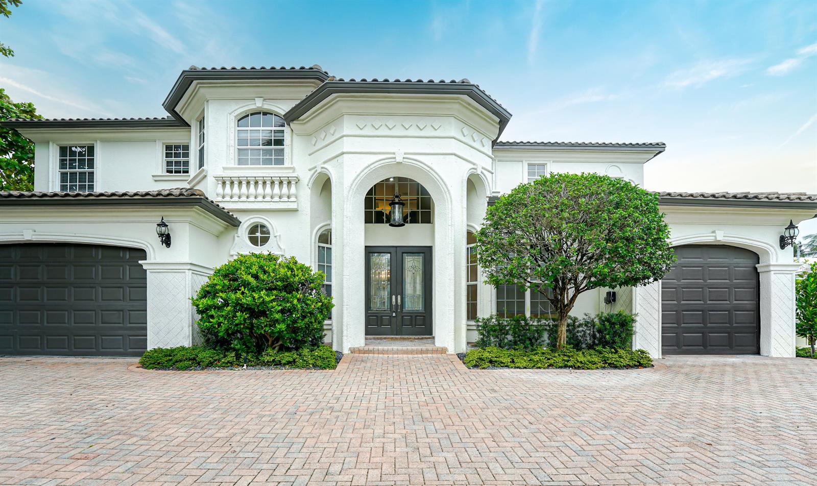 A two-story white stucco house features a brick driveway, two garages, and a central entryway — 749 NE 71st Street, Boca Raton FL 33487, BOCA RATON, FL