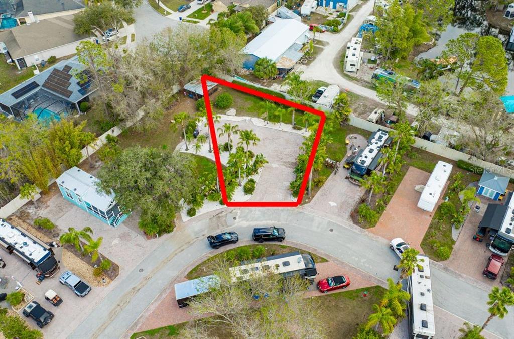 An aerial view shows a vacant, landscaped lot outlined in red within a residential community — 6861 AMANDA VISTA CIRCLE, LAND O LAKES, FL