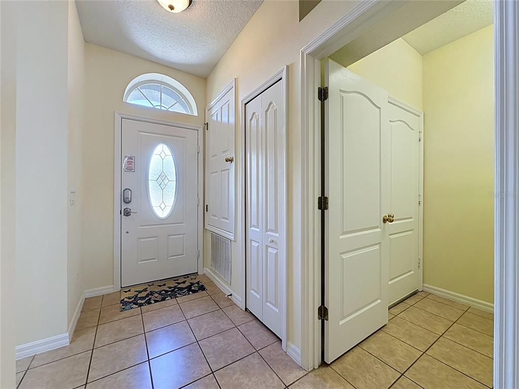 A tiled entryway features a white front door with a window and several interior doors — 906 DORSET PLACE, DAVENPORT, FL